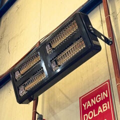 Yüksek tavanlı tesiste duvara sağlam bir şekilde monte edilmiş ağır sanayi tipi ELCON EIR-TH-8 Infrared Fabrika Isıtıcısı.