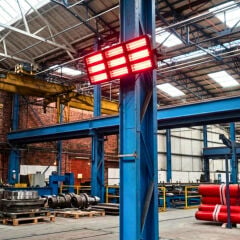 Ağır sanayi üretim tesisinde çelik kolona monte edilmiş ELCON EIR-TH 18 programlanabilir infrared fabrika ısıtma sistemi.